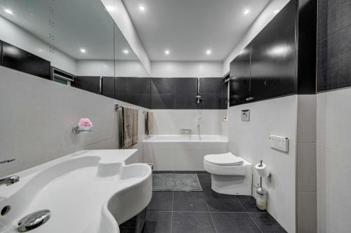 a bathroom with a tub and a toilet and a sink at Unique - Spacious 3BR Premium Flat in Is-Swieqi