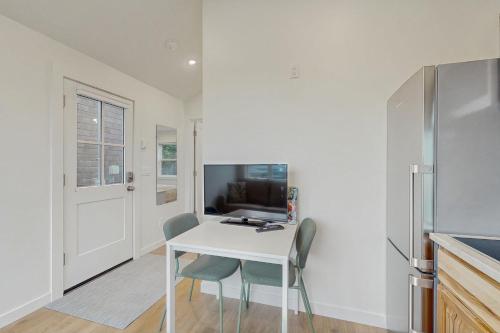 a kitchen with a white table and chairs and a refrigerator at Baerfoot Bungalow in Cannon Beach