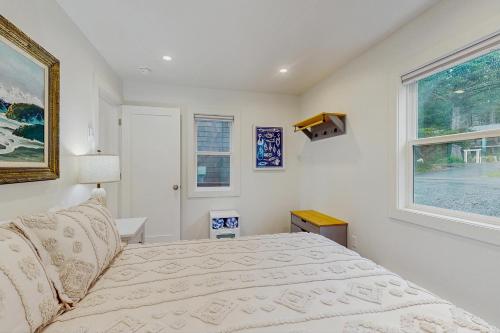 a bedroom with a bed and a window at Baerfoot Bungalow in Cannon Beach