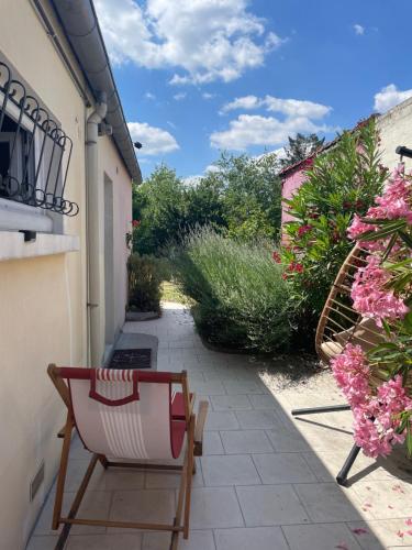 a patio with a chair and flowers in a yard at Chez Sophie in Orléans