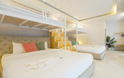 two beds in a room with two bunk beds at Beloved Bliss Pool Villa Bangsaen พูลวิลล่าบางแสนมีสไลด์เดอร์ in Chon Buri