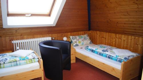 a room with two beds and a chair in it at Villa Bruderfels, Garni in Rodalben