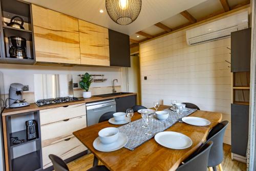 a kitchen with a wooden table with chairs around it at Les Chalets du Lac - Amnéville Cité des Loisirs Galaxie in Amnéville