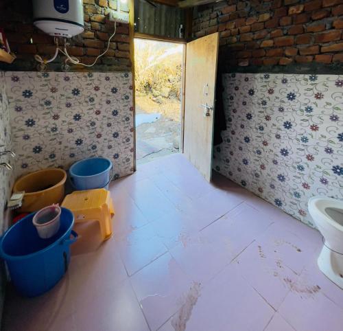 a room with a bathroom with a toilet and a door at Mj home in Kalgha