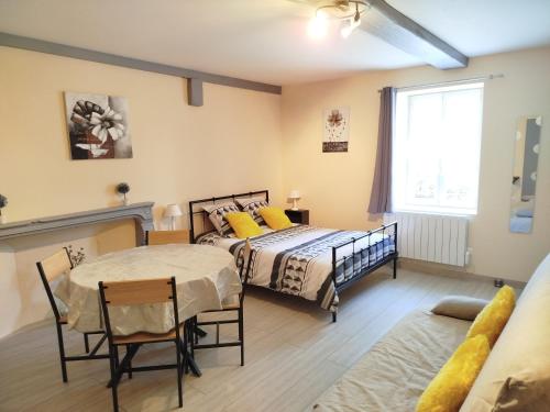 a bedroom with two beds and a table and chairs at L'Epinette in Torchefelon