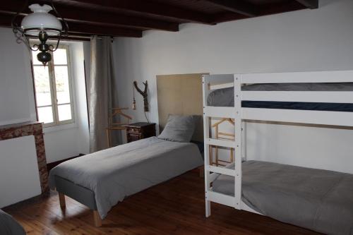 a bedroom with two bunk beds and a window at Oasis de Compostelle in Lauzerte