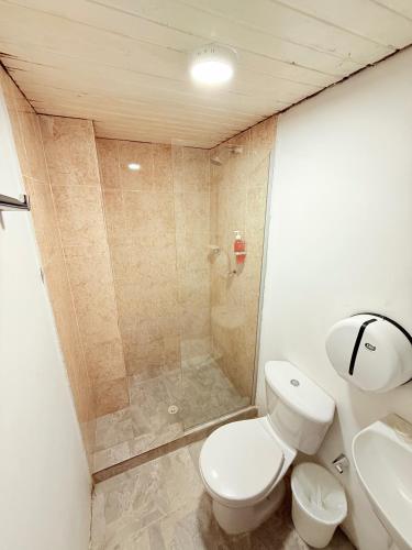 a bathroom with a shower and a toilet and a sink at Hotel Toledo FL in Cartagena de Indias