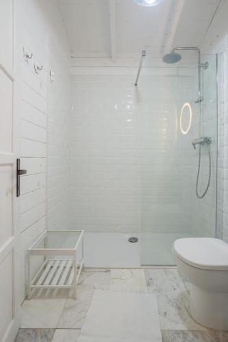 a white bathroom with a shower and a toilet at Casa Blanca Olimp in Olimp