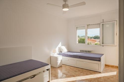 a bedroom with two beds and a window at Casa con jardín en Besalú, ideal para familias in Besalú
