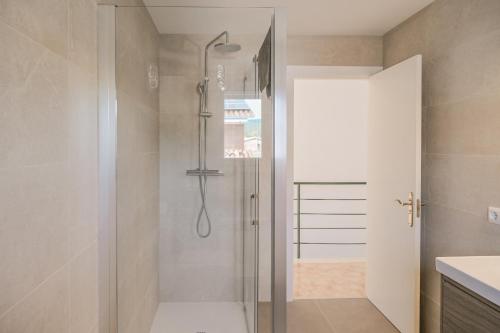 a shower with a glass door in a bathroom at Casa con jardín en Besalú, ideal para familias in Besalú