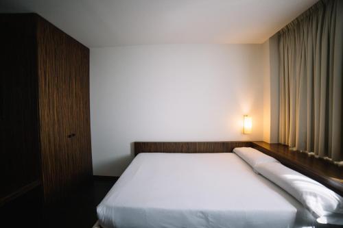 ein Schlafzimmer mit einem weißen Bett, auf dem eine Lampe hängt in der Unterkunft ETH Rioja in Haro