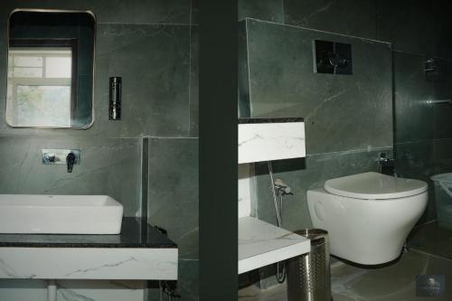 a bathroom with a toilet and a sink and a mirror at The Oaks - Scenic Couple Retreat in Kasauli with Private Balcony Views in Kasauli