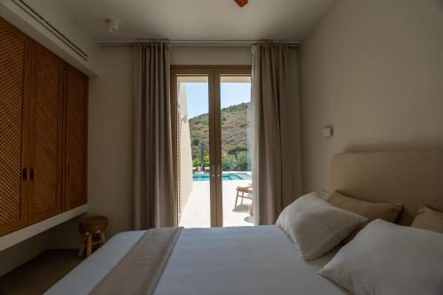 a bedroom with a bed and a door to a pool at Oleander Evia in Agioi Apostoli