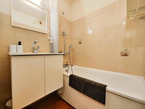 a bathroom with a bath tub and a sink and a bath tub at Charmant studio montagne - vue dégagée - pied des pistes in Mijoux
