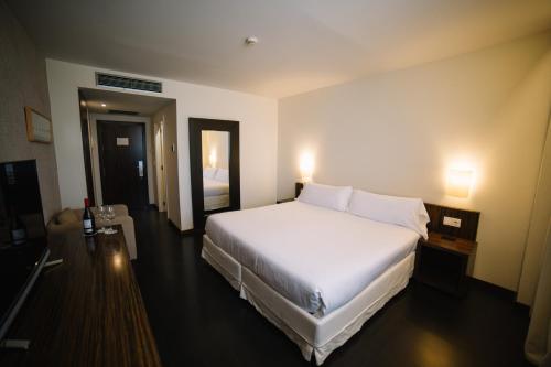 ein großes weißes Bett in einem Hotelzimmer in der Unterkunft ETH Rioja in Haro