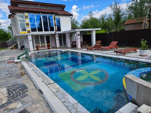 a swimming pool in front of a house at vila darkoni in Bijeljina