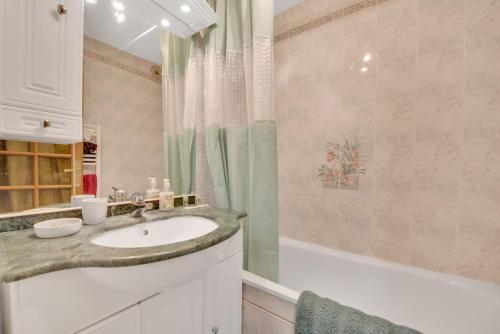 a bathroom with a sink and a shower and a tub at L'Échappée Belle de Houlgate 2 personnes in Houlgate