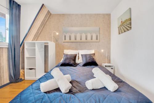 a bedroom with a large blue bed with white pillows at L'Échappée Belle de Houlgate 2 personnes in Houlgate
