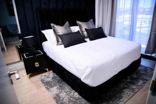 a bedroom with a large bed with white sheets and pillows at SoftStay Ellipse Luxury Apartment in Midrand