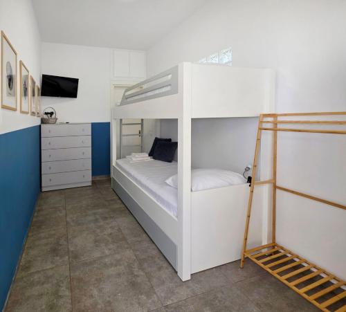 a bedroom with two bunk beds and a tv at KYMO Private Seafront Residence in Koutsourás