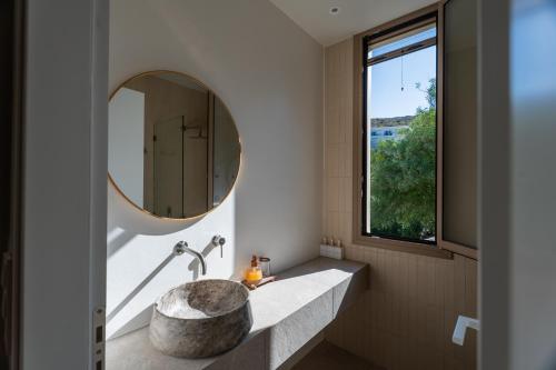 a bathroom with a large stone sink and a mirror at Oleander Evia in Agioi Apostoli