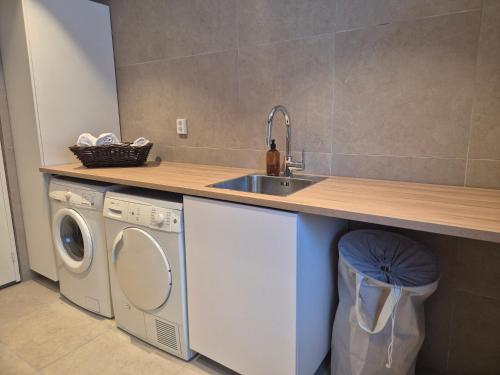 a kitchen with a sink and a washing machine at Utleiebolig Fannrem in Fannrem