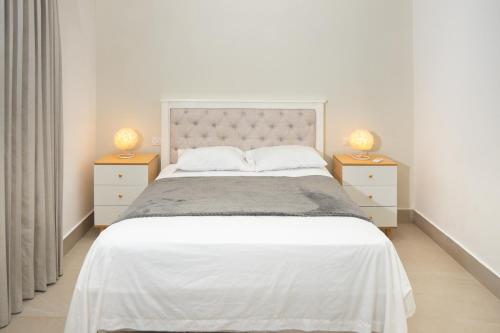 a bedroom with a large white bed with two night stands at Star Villa Boca Chica in Boca Chica