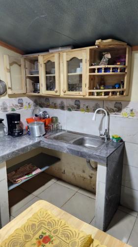 a kitchen with a sink and wooden cabinets at Villa Tungurahua in Huamboya