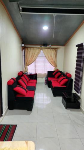 a living room with black couches and red pillows at Villa Tungurahua in Huamboya