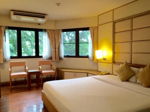a hotel room with a bed and a table and chairs at For You Residence in Bangkok
