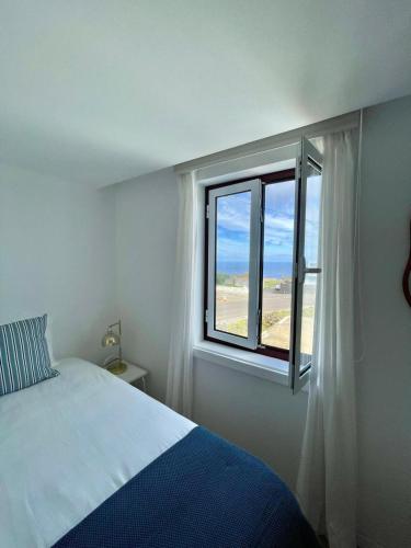 a bedroom with a bed and a window at Casa da Avó Elvina in Angra do Heroísmo