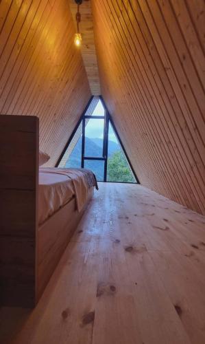 a bedroom with a bed and a wooden floor at Mountain Hearth in Zeda Ch'khutunet'i