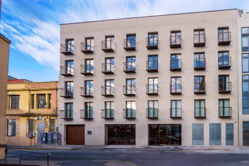 a large white building with windows at easyHotel Valencia Ciutat Vella in Valencia