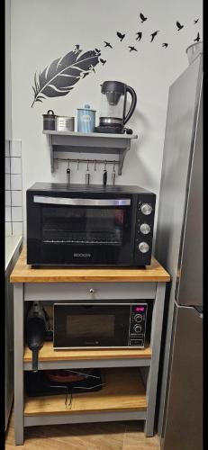a microwave oven sitting on a table in a kitchen at Casa do Aconchego em Freiria in Freiria