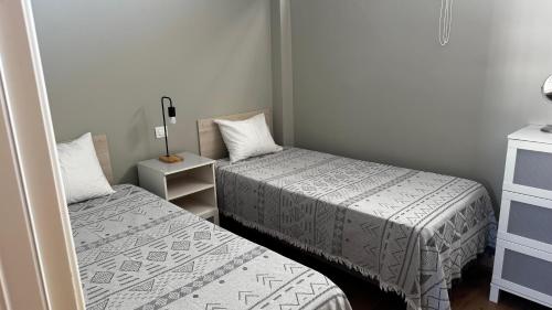 a small room with two beds and a dresser at Apartamento en Playa del Ingles CC Yumbo in Maspalomas