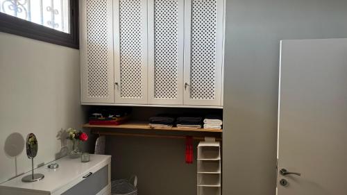 a bathroom with a sink and white cabinets at Apartamento en Playa del Ingles CC Yumbo in Maspalomas
