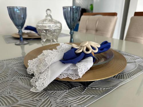 a table with a plate with a napkin on it at Refúgio Azul Vog Ville Sul in Caruaru