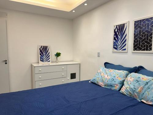 a bedroom with a blue bed and a dresser at Refúgio Azul Vog Ville Sul in Caruaru