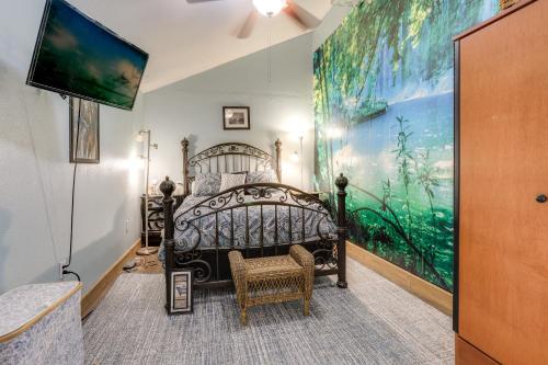 a bedroom with a bed with a large painting on the wall at 2 Mi to LSU Mid City Home with Yard and Patio! in Baton Rouge