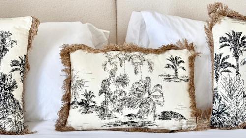 two pillows on a bed with palm trees at Bayab Charming Rooms - Corso Garibaldi in Benevento