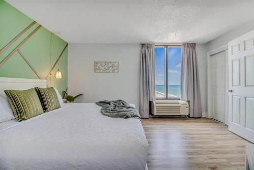 a bedroom with a bed and a window with the ocean at Oceanfront Suite, Seascape Sanctuary at OceanPark! 1104 in Myrtle Beach