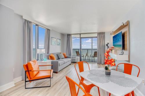 a living room with a table and chairs and a couch at Oceanfront Suite, Seascape Sanctuary at OceanPark! 1104 in Myrtle Beach