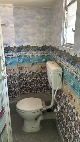 a bathroom with a toilet and a painting on the wall at Apartment in Khardaha in Khardah