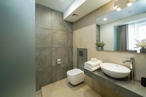 a bathroom with a sink and a toilet and a mirror at Thassos OLIVIA RESORT in Potos