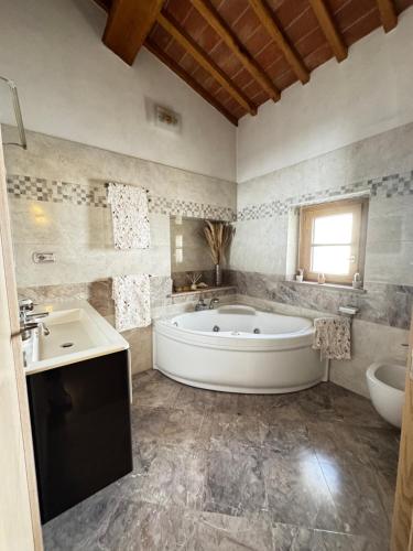 a large bathroom with a tub and a sink at La Casa di Thor in Porto Azzurro