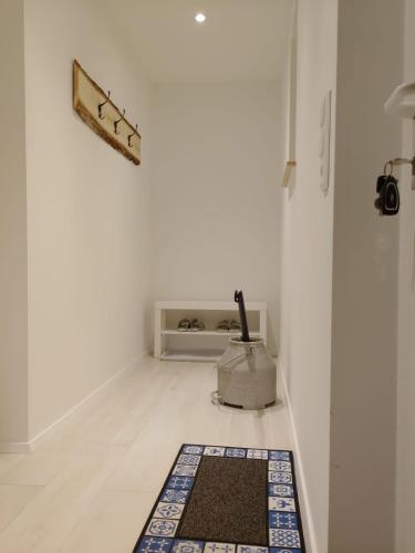 a white hallway with a rug on the floor at Ferienhaus Marion in Steinhagen