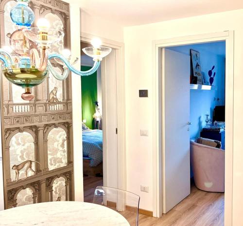a dining room with a chandelier and a bedroom at Maison Lake Maggiore Art Stay,central Baveno, 60 mt from Lake and Hotel Dino Congress Center in Baveno