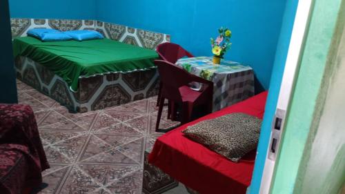 a room with a table and a bed and a table and a table sidx sidx at Pousada Nosso cantinho in Belém