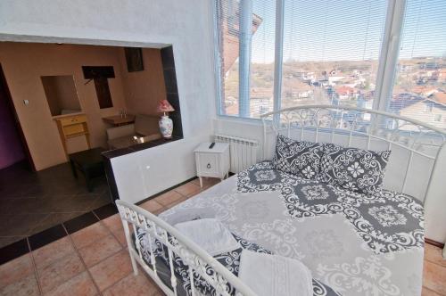 a bedroom with a white bed and a window at Snow Heaven Hotel in Bankya