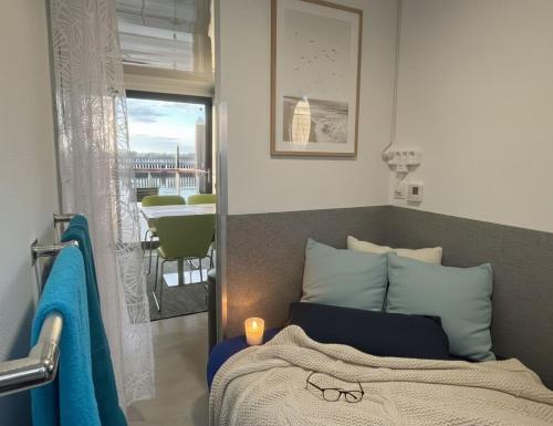 a bedroom with a bed and a view of a balcony at ÖKO Budget Hausboot Retreat Morgenrot in Stralsund